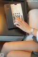 A woman is typing on a telephone on a table.