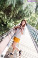 A woman standing on a bridge with her hands on her hips.