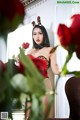 A woman in a leopard print lingerie holding a red rose.