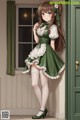 A girl in a green dress and white stockings standing in front of a door.