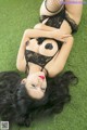 A woman laying on the grass in a black lingerie.