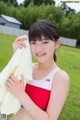 A young woman in a red and white bathing suit holding a towel.