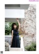 A woman in a black dress standing on a balcony.